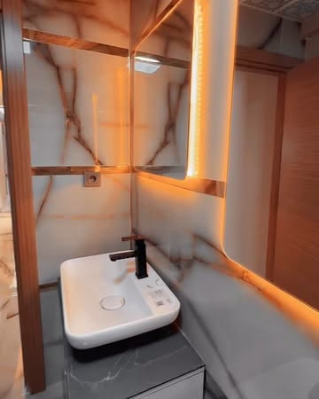 Mermer desenli, ışıklı aynalı banyo